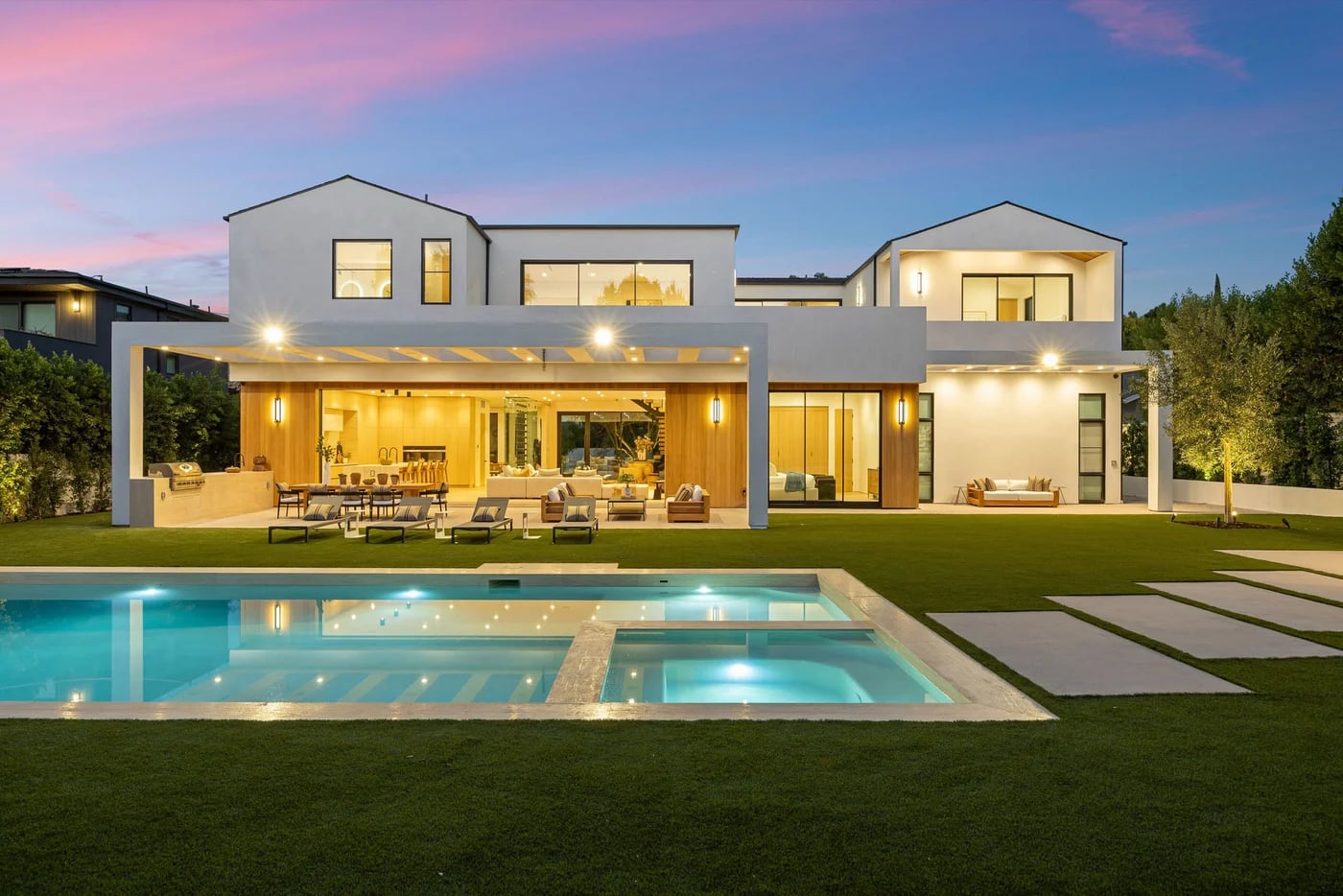 Villa contemporánea con piscina iluminada al atardecer